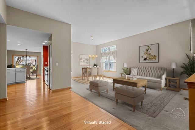 13731 S Tamarack Dr, Plainfield, IL 60544 - living room featuring an inviting chandelier, light wood-style floors, and baseboards
