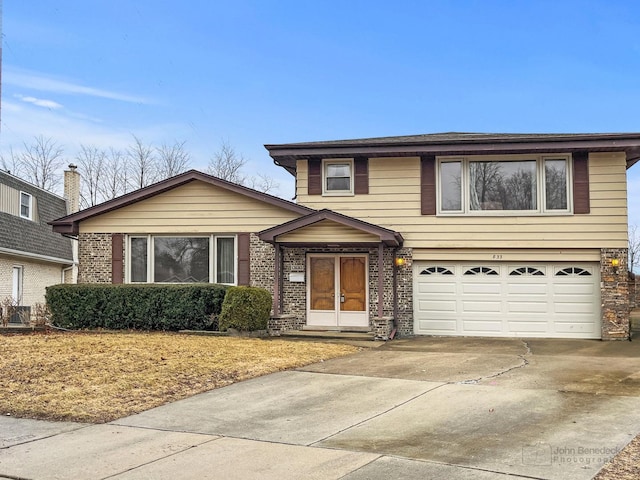 view of front of property featuring an attached garage, concrete driveway, and brick siding