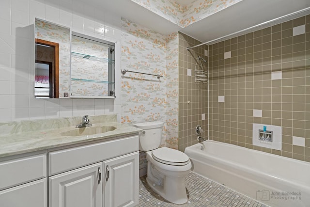 full bathroom with toilet, vanity,  shower combination, tile patterned flooring, and wallpapered walls