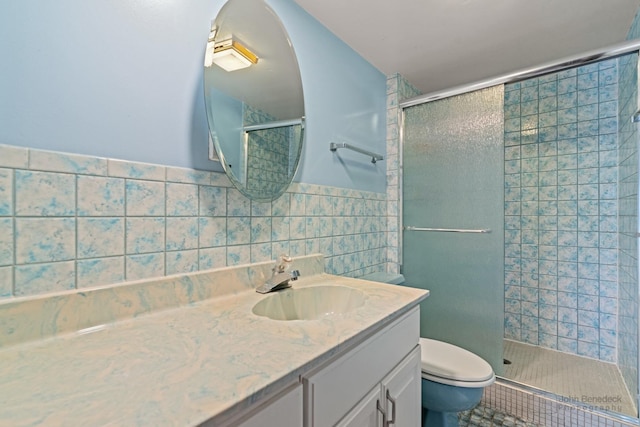 bathroom featuring toilet, vanity, a shower stall, and tile walls