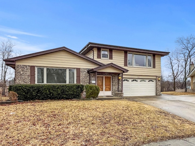 view of front of home with concrete driveway, brick siding, and an attached garage