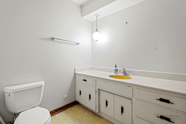 half bath featuring toilet, baseboards, and vanity