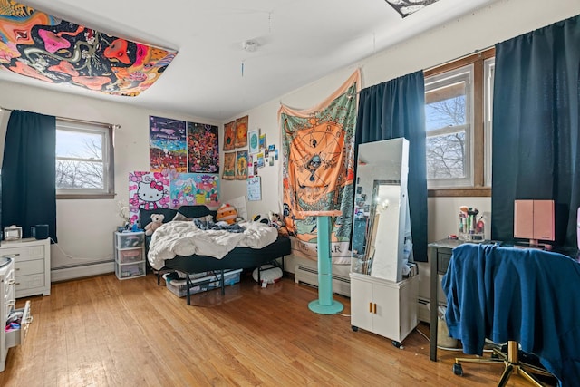 bedroom with light wood-type flooring and baseboard heating