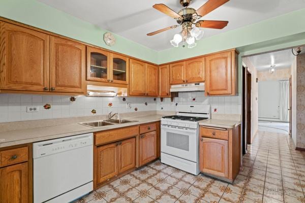 kitchen featuring white appliances, light countertops, a sink, and under cabinet range hood