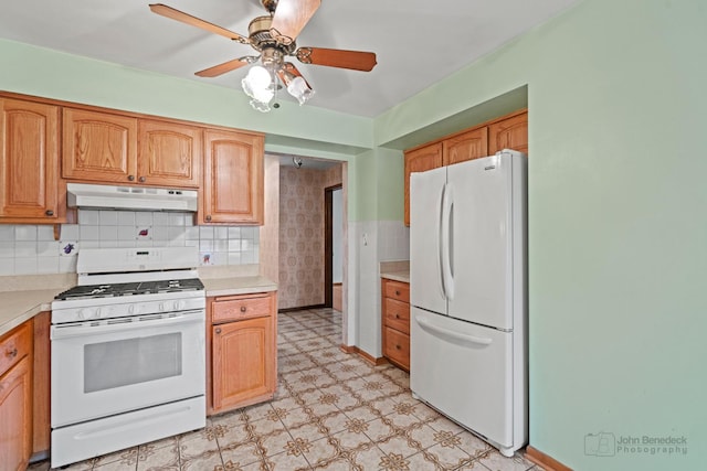 kitchen with white appliances, under cabinet range hood, light countertops, and light floors