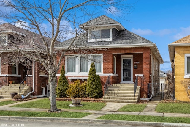 view of front of property featuring brick siding and roof with shingles