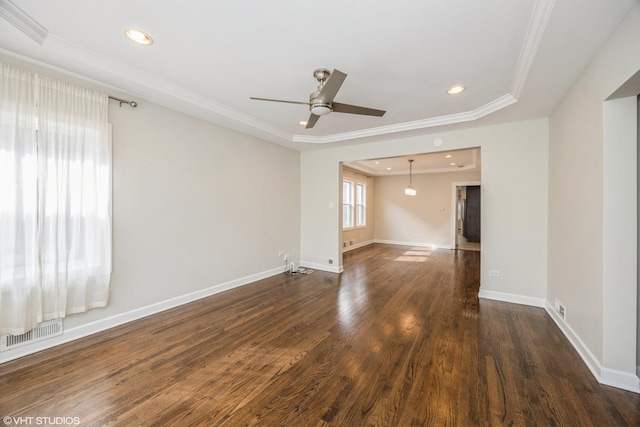 spare room featuring visible vents, a raised ceiling, dark wood finished floors, crown molding, and recessed lighting