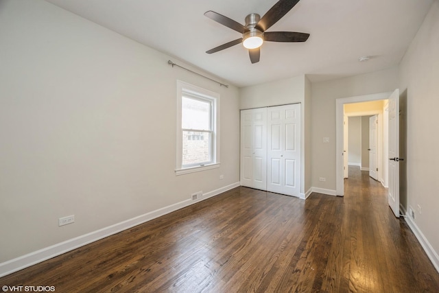 unfurnished bedroom with visible vents, baseboards, dark wood finished floors, and a closet