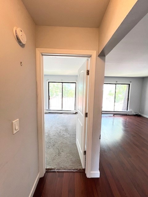 hallway with baseboards and wood finished floors