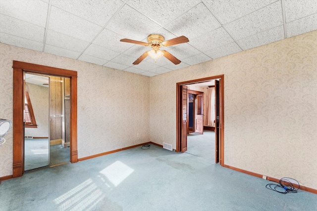 spare room featuring wallpapered walls, ceiling fan, visible vents, and carpet flooring