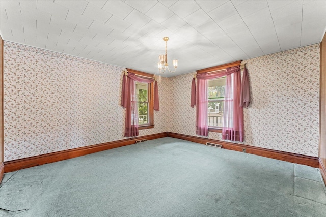 spare room with carpet, visible vents, baseboards, and wallpapered walls