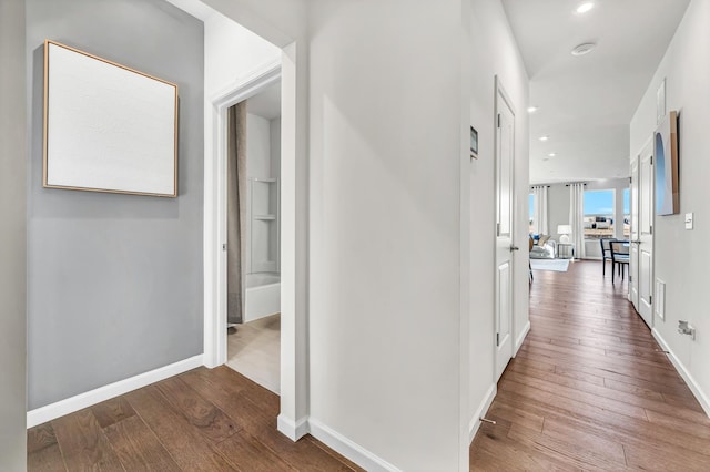 corridor featuring recessed lighting, baseboards, and hardwood / wood-style floors