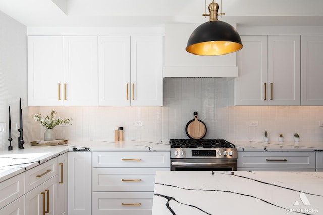 kitchen featuring gas range, white cabinetry, decorative backsplash, and light stone counters