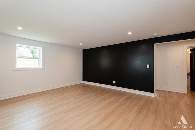 unfurnished room with an accent wall, light wood-type flooring, baseboards, and recessed lighting