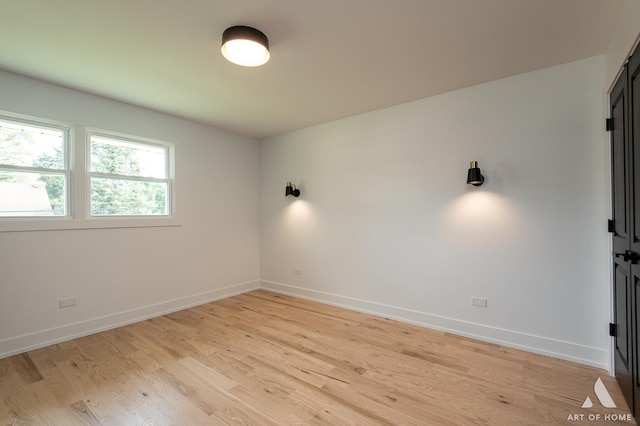 unfurnished room with light wood-type flooring and baseboards