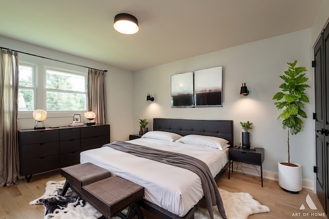 bedroom with light wood-style flooring and baseboards