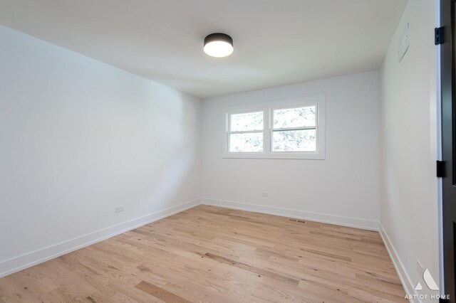 spare room featuring light wood-style flooring and baseboards