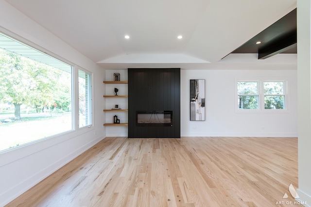 interior space with a fireplace, light wood finished floors, recessed lighting, vaulted ceiling, and baseboards