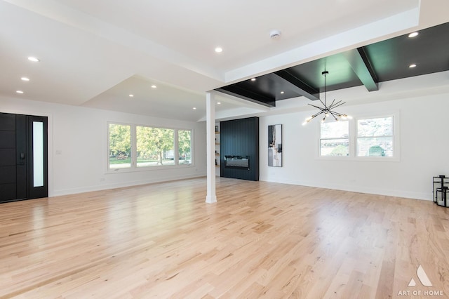 unfurnished living room with a chandelier, recessed lighting, baseboards, light wood-type flooring, and beam ceiling