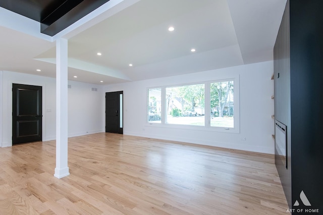 unfurnished living room featuring baseboards, a fireplace, light wood-style flooring, and recessed lighting