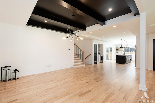 unfurnished living room featuring light wood-style flooring, stairs, beam ceiling, a notable chandelier, and recessed lighting