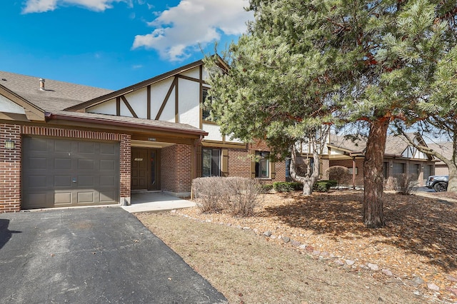 english style home with brick siding, roof with shingles, stucco siding, a garage, and driveway