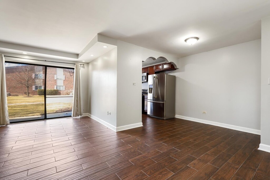 kitchen featuring wood tiled floor, stainless steel appliances, a sink, and light countertops