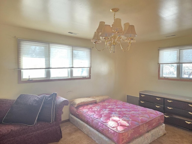 bedroom with a chandelier, light colored carpet, and visible vents