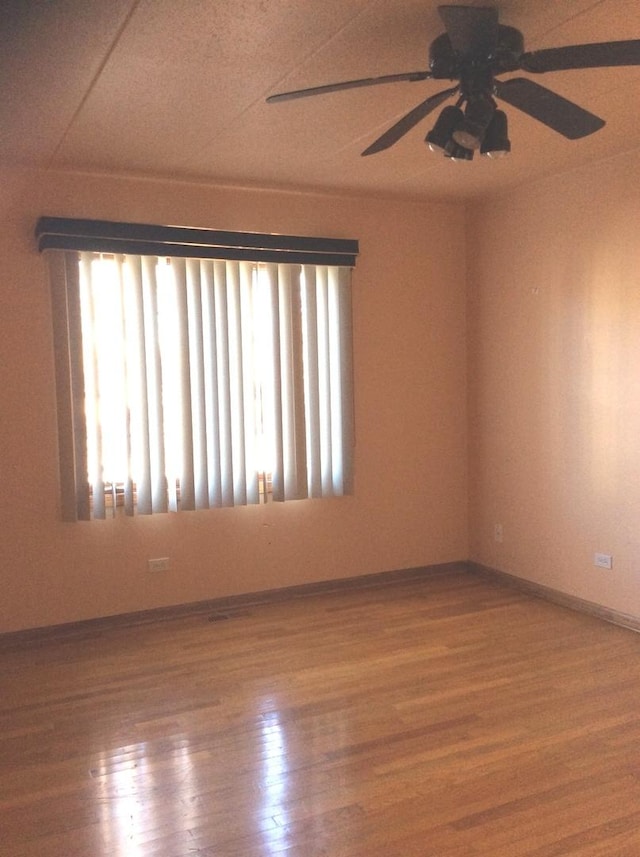 unfurnished room featuring baseboards, ceiling fan, and wood finished floors