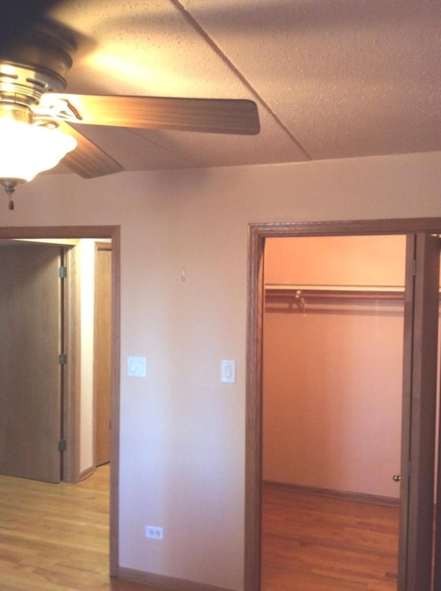 unfurnished bedroom featuring a ceiling fan, a closet, and light wood finished floors