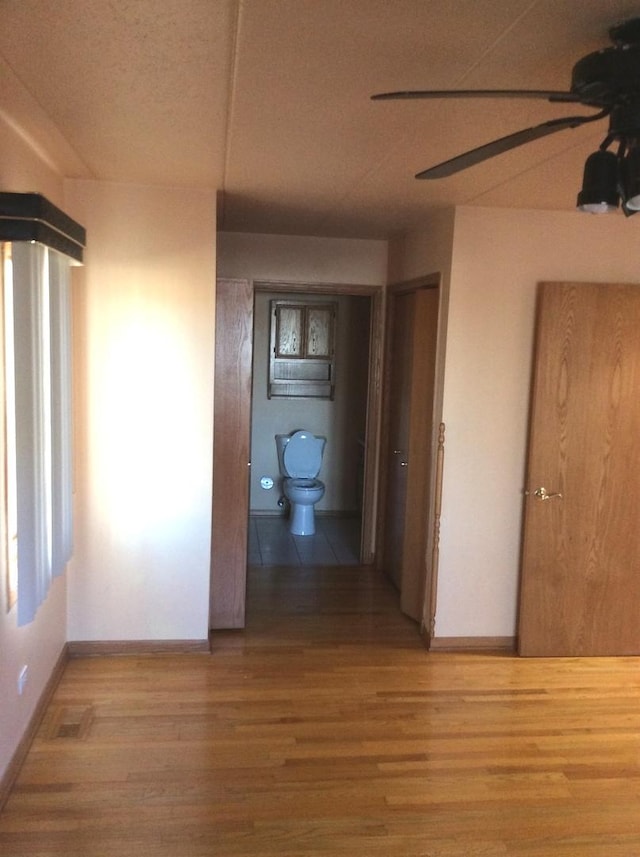 hall featuring baseboards and wood finished floors