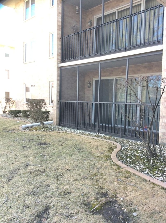 back of house with stucco siding and a balcony