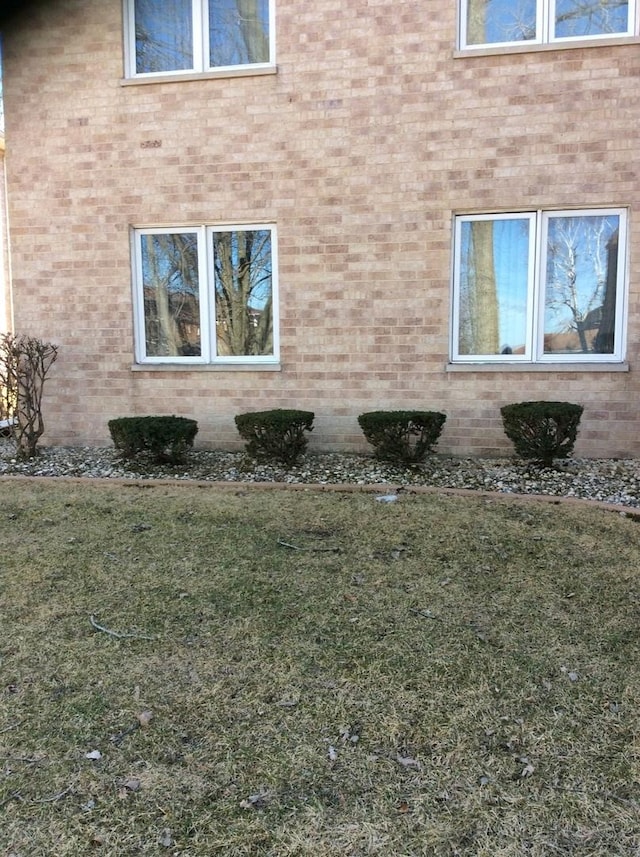 view of property exterior featuring a yard and brick siding