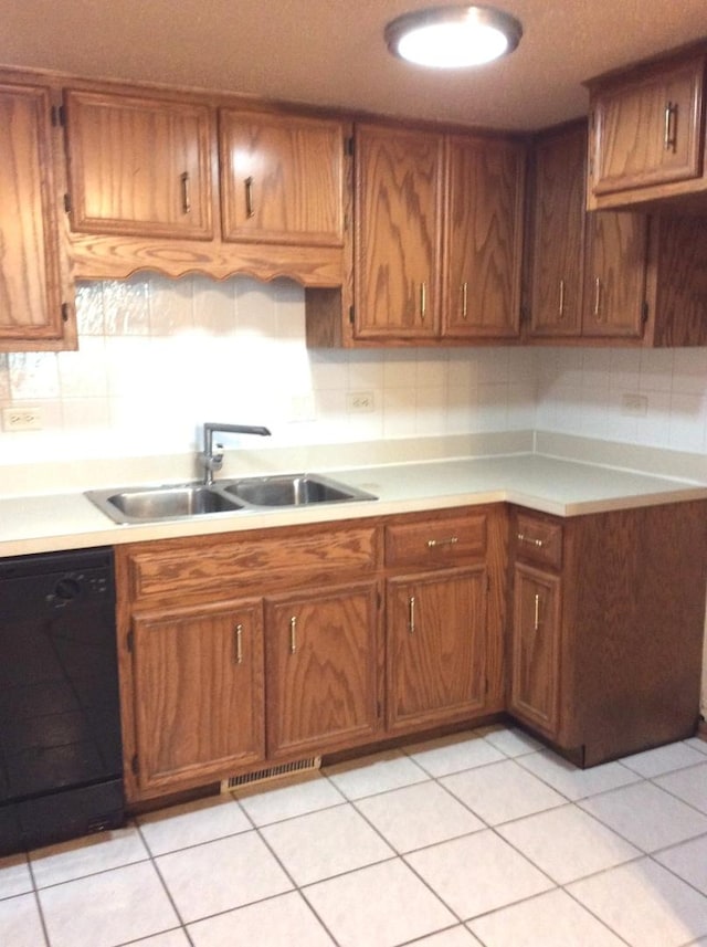 kitchen featuring a sink, brown cabinets, black dishwasher, and light countertops