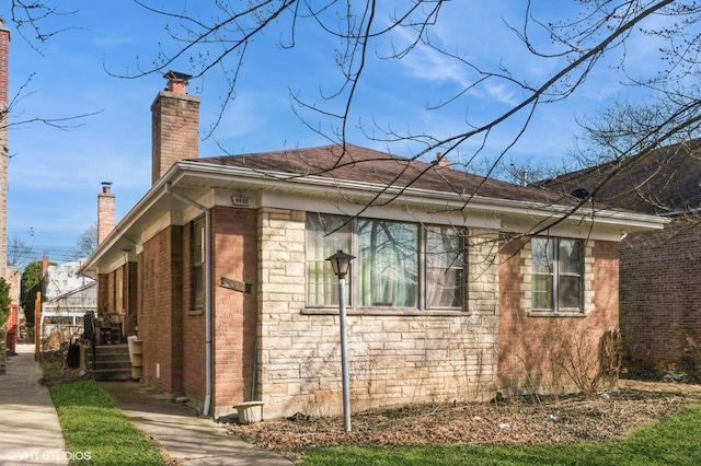 view of side of home featuring brick siding and a chimney