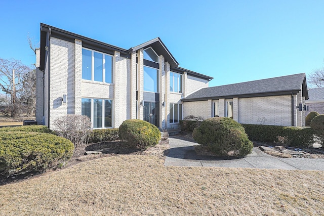 view of front facade featuring brick siding and a front lawn