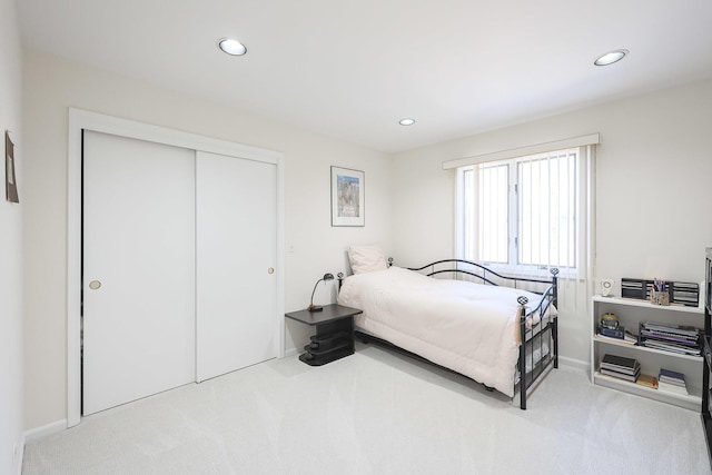 carpeted bedroom with a closet and recessed lighting