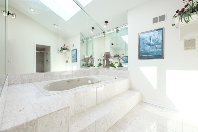 full bath featuring visible vents, a shower stall, lofted ceiling with skylight, a garden tub, and tile patterned floors