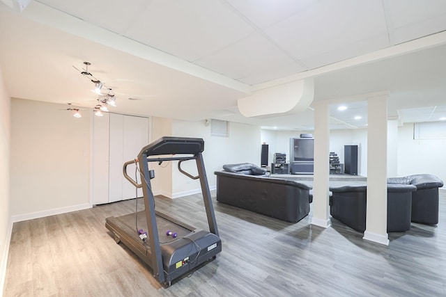 exercise area with baseboards and wood finished floors