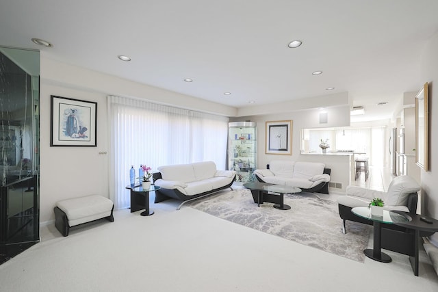 living room featuring a wealth of natural light, visible vents, recessed lighting, and carpet flooring