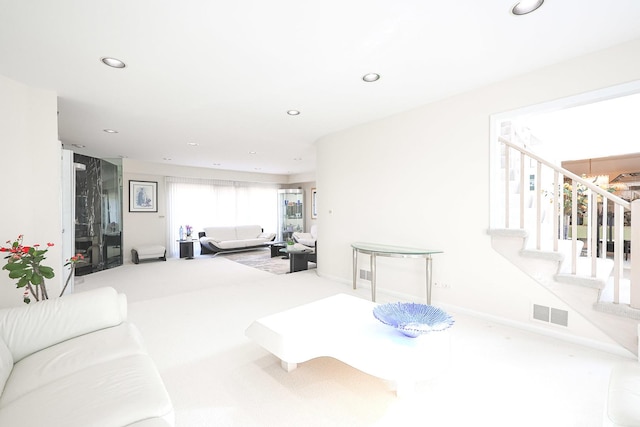 living area featuring stairs, recessed lighting, and visible vents