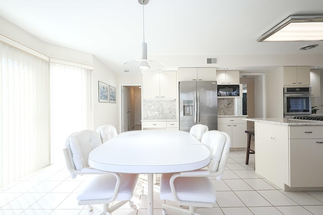 dining area featuring light tile patterned floors and visible vents