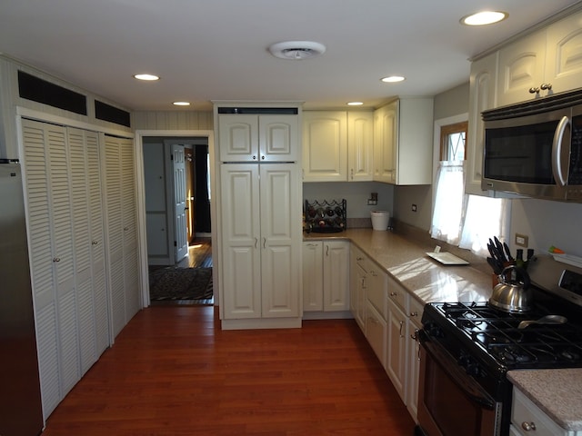 kitchen with recessed lighting, white cabinetry, stainless steel appliances, and dark wood-style flooring