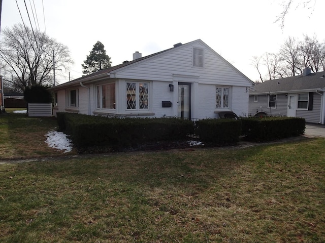 view of front of home featuring a front lawn and a chimney
