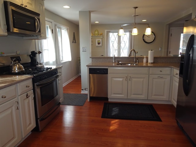 kitchen featuring dark wood-type flooring, recessed lighting, stainless steel appliances, white cabinetry, and a sink