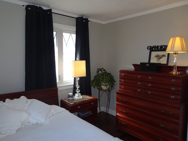 bedroom featuring dark wood finished floors and crown molding
