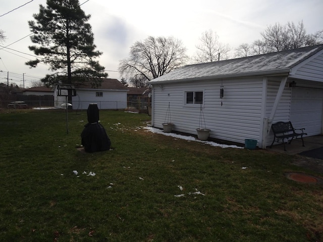 view of yard featuring an outdoor structure, fence, and a garage