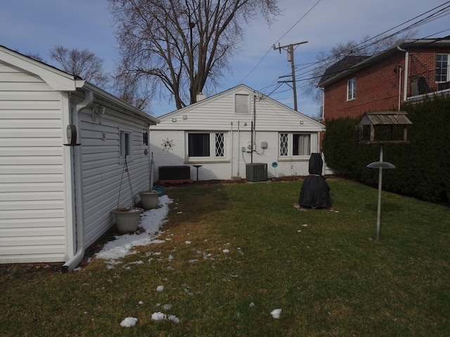 rear view of property featuring a lawn and cooling unit