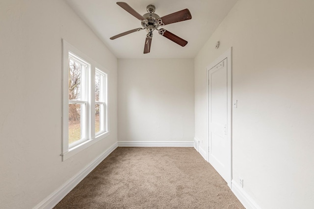 empty room featuring carpet, baseboards, and ceiling fan