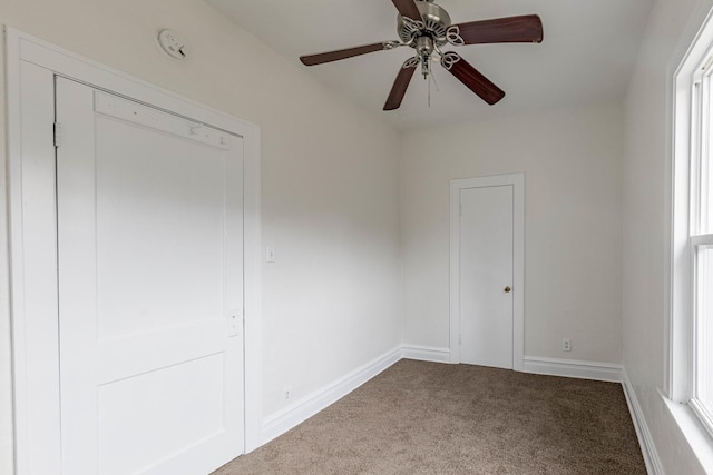 empty room featuring carpet floors, ceiling fan, and baseboards